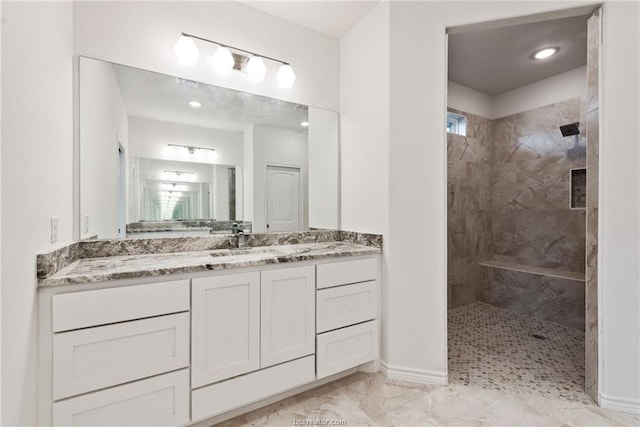 bathroom with vanity and a tile shower