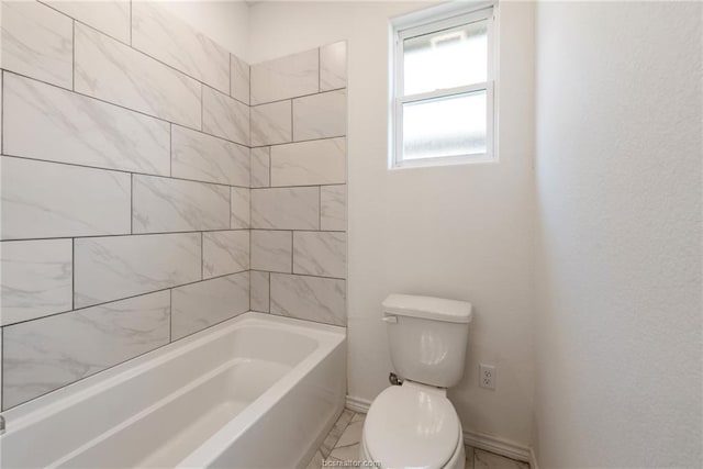 bathroom with tiled shower / bath combo and toilet