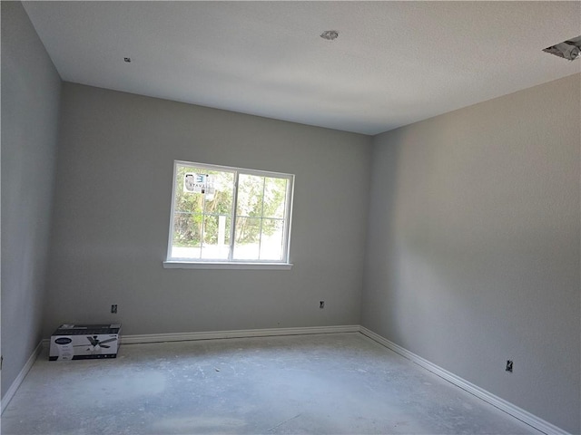 1112 Justine, Bryan, TX 77803 - empty room with unfinished concrete floors and baseboards