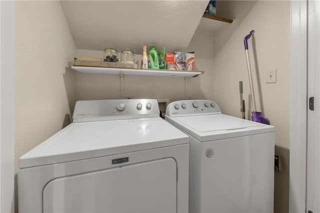 laundry area with a textured ceiling and washing machine and clothes dryer