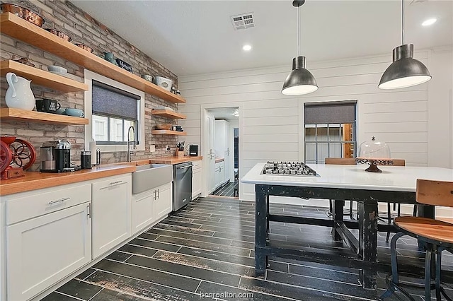 kitchen with dishwasher, white cabinets, decorative light fixtures, backsplash, and sink