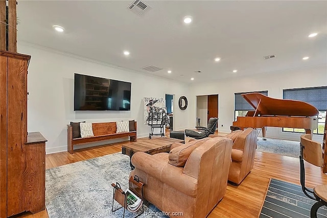 living room with crown molding and light hardwood / wood-style floors