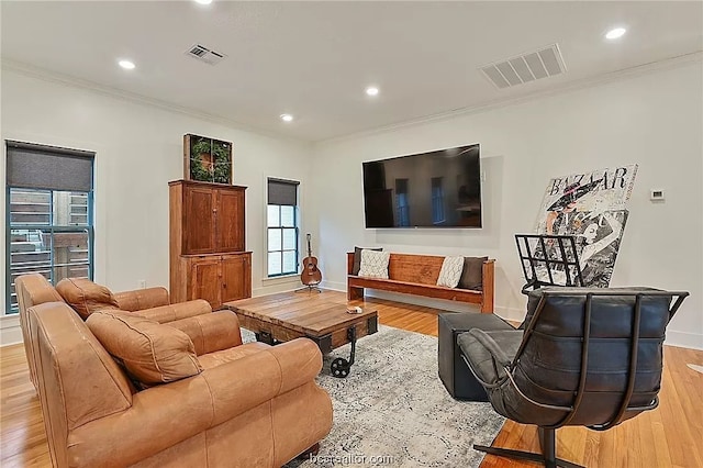 living room with light wood-type flooring and ornamental molding