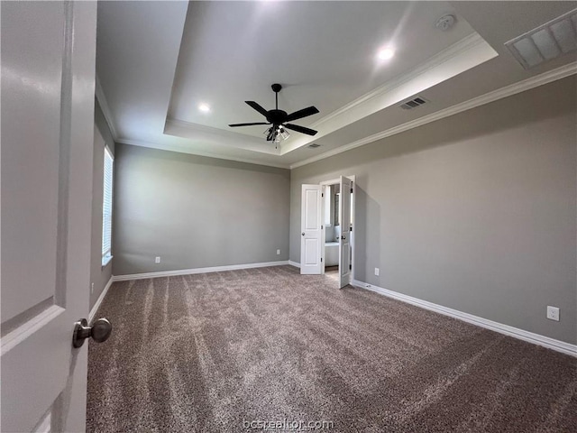 empty room featuring carpet floors, a tray ceiling, and crown molding