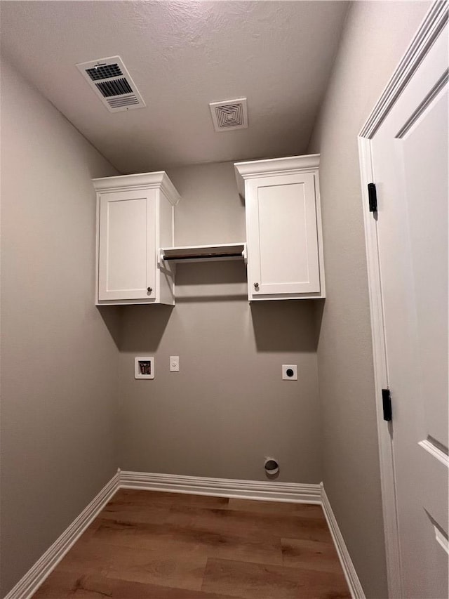 washroom with hardwood / wood-style floors, electric dryer hookup, a textured ceiling, and hookup for a washing machine