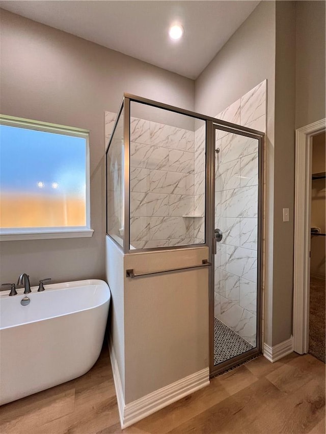 bathroom with hardwood / wood-style flooring and separate shower and tub