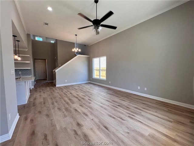 2126 Mountain Wind Loop, Bryan, TX 77807 - unfurnished living room featuring ornamental molding, light wood finished floors, a ceiling fan, a chandelier, and recessed lighting