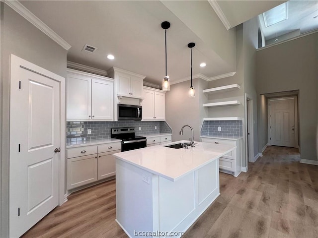 2126 Mountain Wind Loop, Bryan, TX 77807 - kitchen with stainless steel appliances, open shelves, crown molding, white cabinetry, and light countertops
