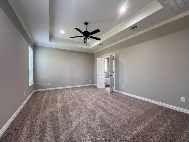 carpeted empty room with ceiling fan, crown molding, and a tray ceiling