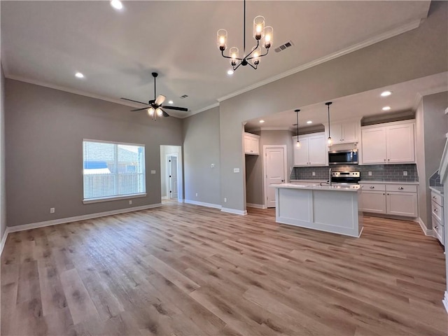 kitchen with appliances with stainless steel finishes, light wood-type flooring, white cabinetry, and ornamental molding