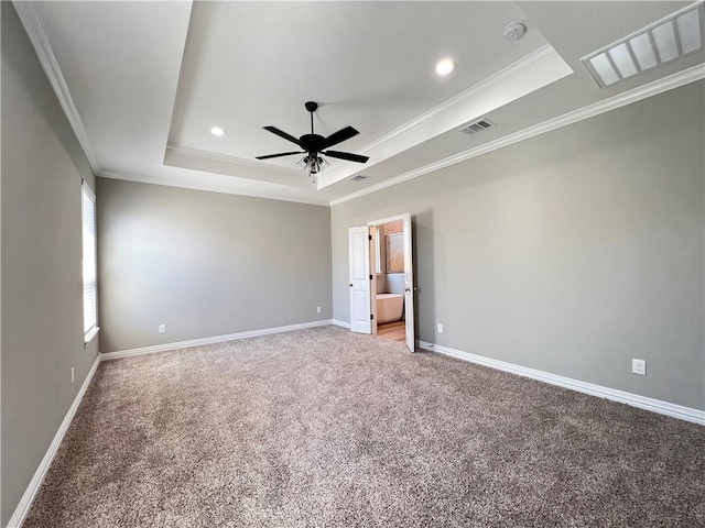 carpeted spare room featuring a tray ceiling, crown molding, and ceiling fan