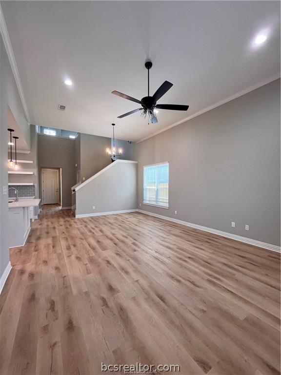 unfurnished living room featuring ceiling fan, light hardwood / wood-style floors, and crown molding