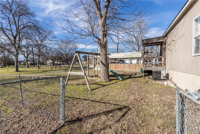 view of yard featuring a playground, fence, and central AC unit