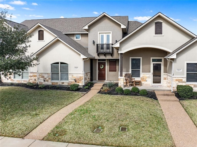 view of front of house featuring a balcony and a front yard