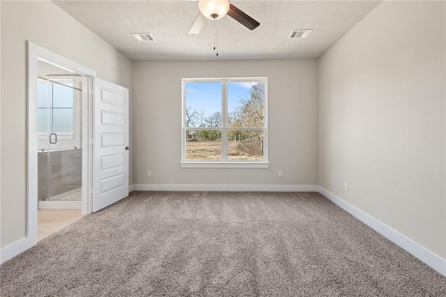 unfurnished bedroom featuring light colored carpet, ceiling fan, and ensuite bathroom