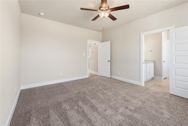 unfurnished bedroom featuring ensuite bathroom, light carpet, and ceiling fan