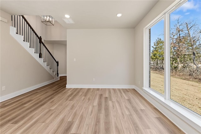 empty room with an inviting chandelier and light wood-type flooring