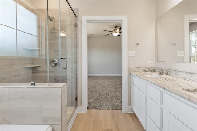 bathroom featuring hardwood / wood-style flooring, ceiling fan, vanity, and a shower with door