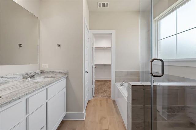 bathroom with vanity, hardwood / wood-style floors, and independent shower and bath