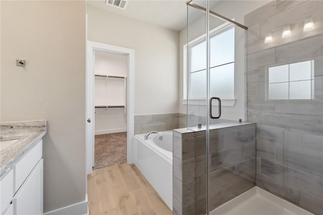 bathroom with vanity, hardwood / wood-style floors, and independent shower and bath