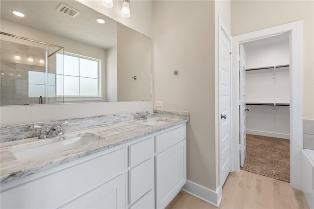 bathroom with vanity, hardwood / wood-style floors, and a shower with shower door