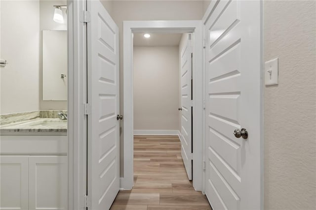 hall featuring sink and light hardwood / wood-style floors