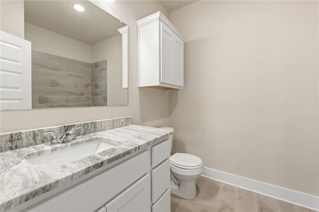 bathroom with vanity, wood-type flooring, and toilet