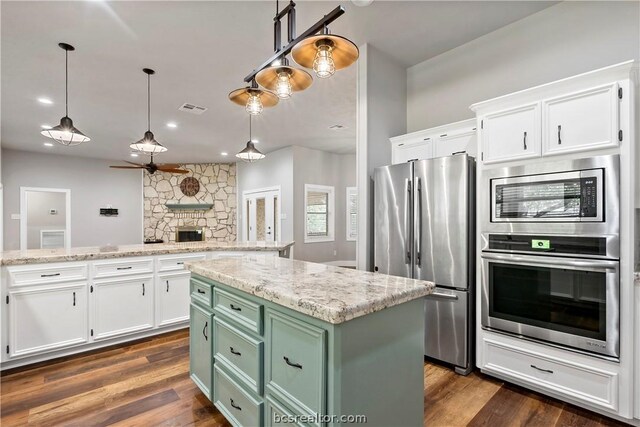 kitchen featuring white cabinets, appliances with stainless steel finishes, a center island, and green cabinetry