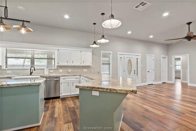 kitchen featuring a center island, dark wood-type flooring, stainless steel dishwasher, decorative light fixtures, and white cabinets