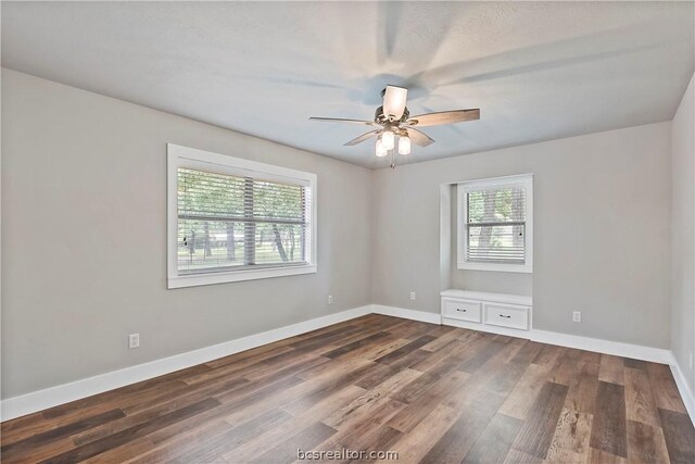 spare room featuring dark hardwood / wood-style flooring and ceiling fan