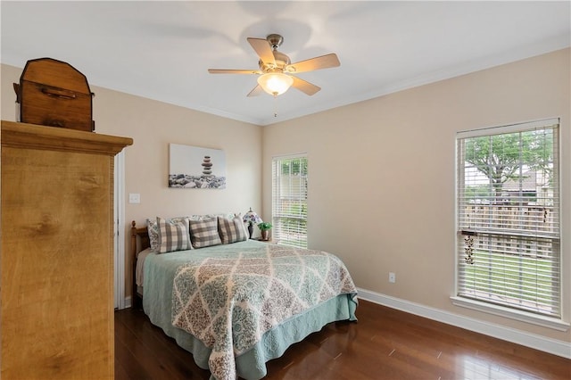 bedroom featuring ceiling fan, ornamental molding, dark wood finished floors, and baseboards