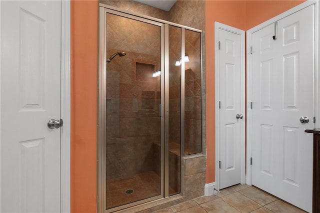 full bathroom with tile patterned floors, a shower stall, and baseboards