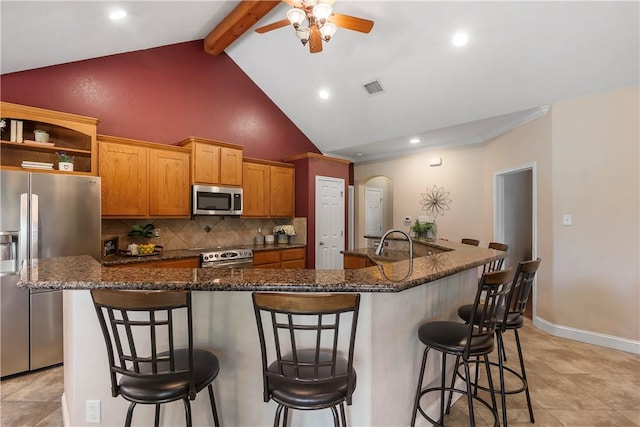 kitchen featuring tasteful backsplash, arched walkways, stainless steel appliances, ceiling fan, and visible vents