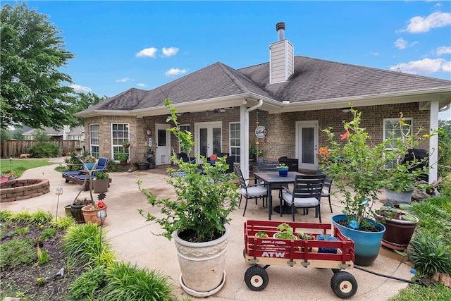back of property featuring a chimney, brick siding, fence, and a patio area