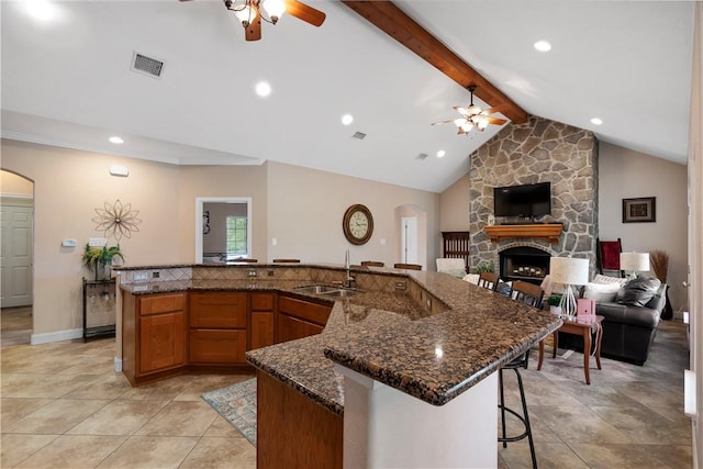 kitchen with arched walkways, ceiling fan, and a sink