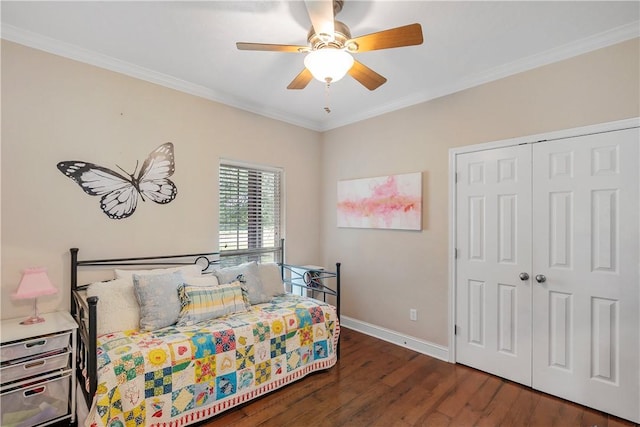 bedroom featuring wood finished floors, a closet, ornamental molding, baseboards, and a ceiling fan