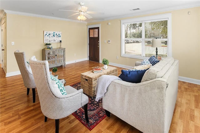 living room with visible vents, wood finished floors, and ornamental molding