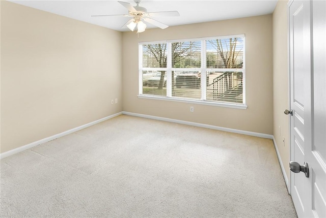 empty room with baseboards, light colored carpet, and a ceiling fan