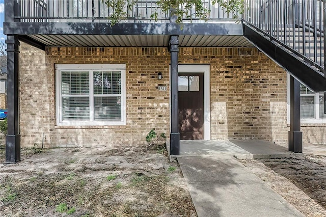 doorway to property featuring brick siding