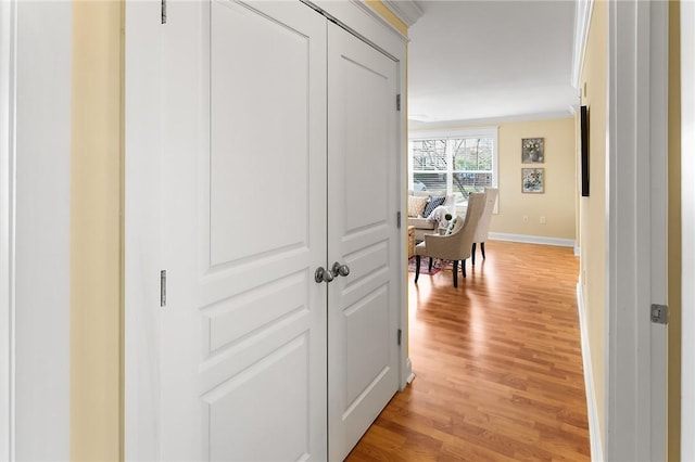 corridor with light wood finished floors and baseboards