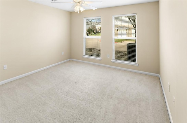 spare room featuring baseboards, a ceiling fan, and carpet