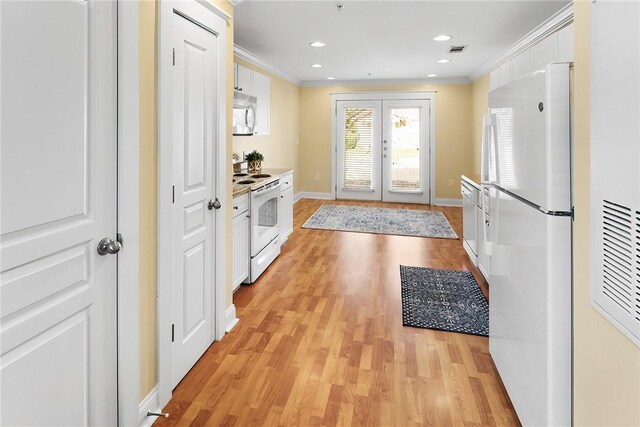 kitchen with white cabinets, white appliances, light wood-style flooring, and ornamental molding