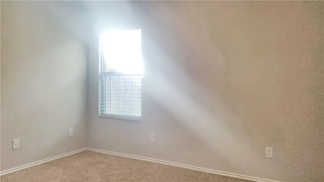 unfurnished room featuring light colored carpet