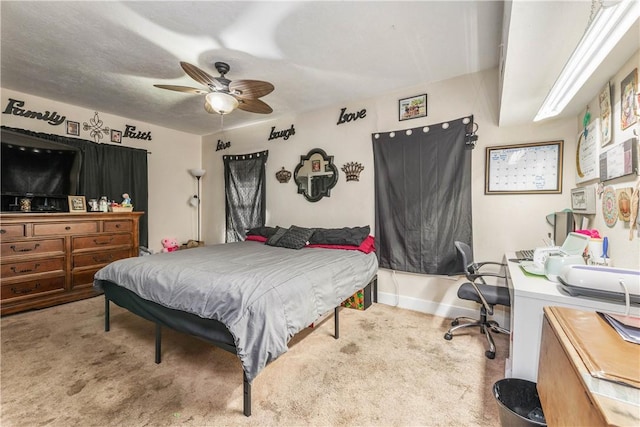 carpeted bedroom with ceiling fan and baseboards