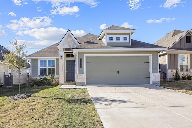 view of front of home featuring a garage, central AC unit, and a front yard