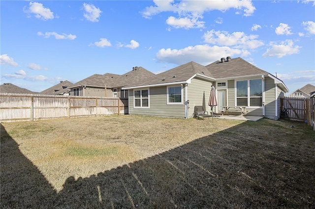 rear view of property featuring a yard and a patio area