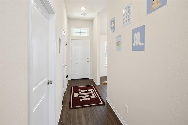 entryway with a towering ceiling and dark wood-type flooring