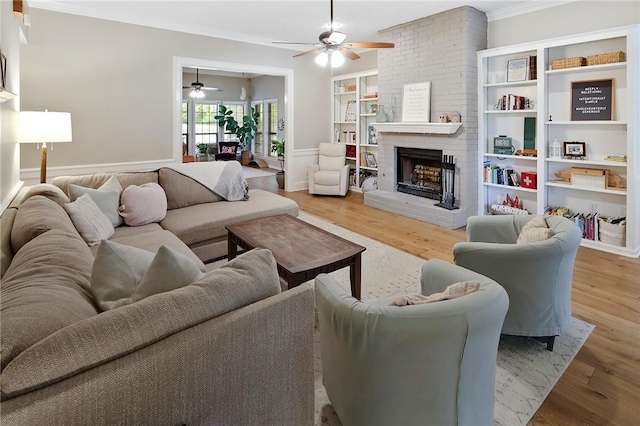 living room with crown molding, hardwood / wood-style floors, and a brick fireplace