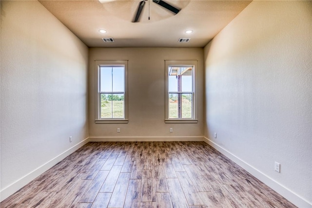 empty room with ceiling fan and light hardwood / wood-style floors