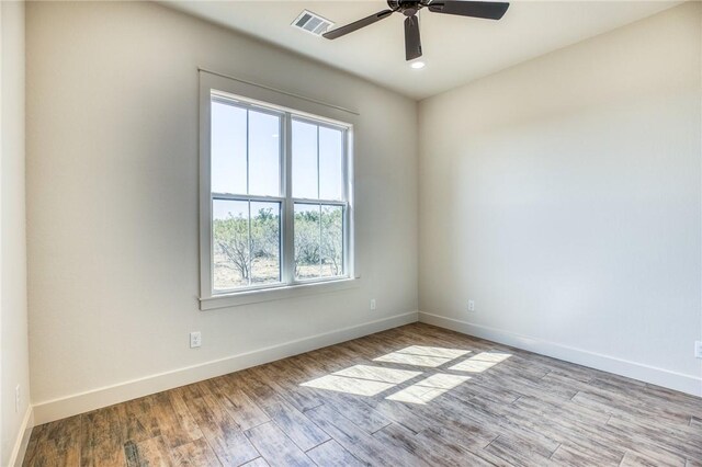 empty room with ceiling fan and light hardwood / wood-style flooring